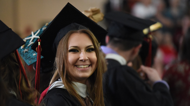 A young woman in the crowd at La Roche University’s commencement ceremony smiles before taking the stage.